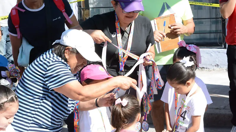 Luego de cruzar la meta les colocaron su medalla. 